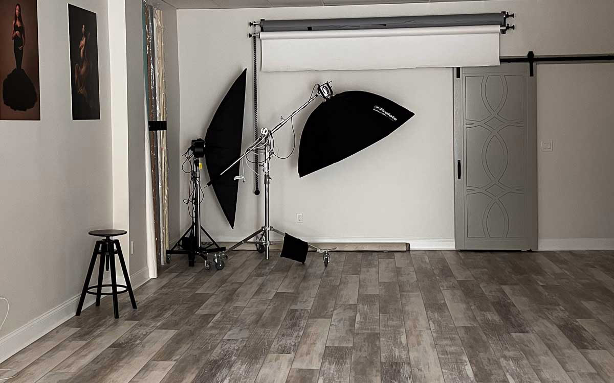 A well-equipped photo studio featuring a spacious mirror and a sturdy tripod for professional photography.