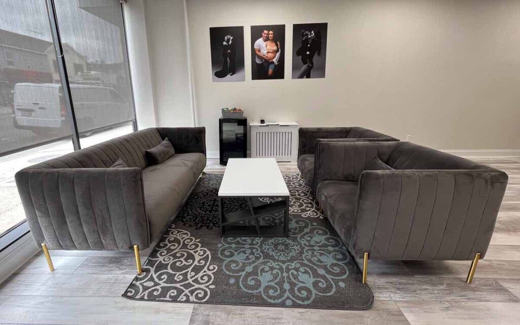A cozy maternity photography studio with comfortable couches and a stylish coffee table.